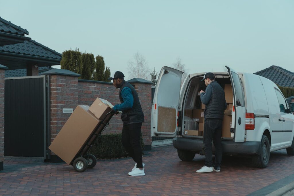 Two delivery men working diligently from a van, showing teamwork and logistics efficiency.